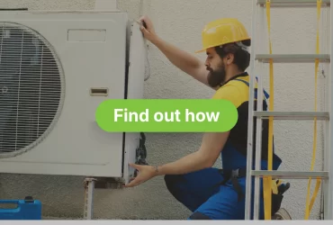 A maintenance technician with a beard is kneeling beside an outdoor air conditioner unit, working on disassembling or fixing it. He is wearing a blue uniform, a yellow and black shirt, and a yellow hard hat. A silver ladder is visible on the right, and a blue toolbox is on the ground to the left. The AC unit is mounted on a white, textured wall.