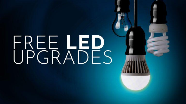 Text reads "FREE LED UPGRADES" with a background showing different types of light bulbs, including a bright LED bulb, an incandescent bulb, and a CFL bulb.